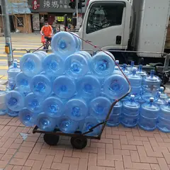 Galões de água de 20 litros empilhados num carrinho de entrega