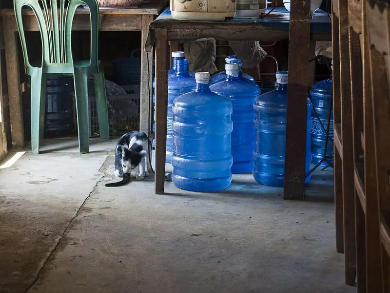 Galões de água de 20 litros guardados sob uma mesa