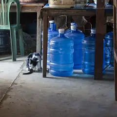 Galões de água de 20 litros guardados sob uma mesa