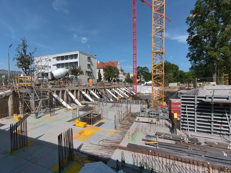Canteiro de obras com grua e estrutura de concreto armado