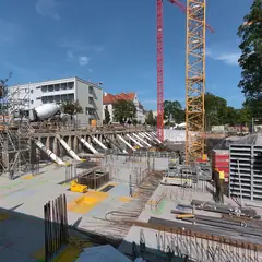 Canteiro de obras com grua e estrutura de concreto armado