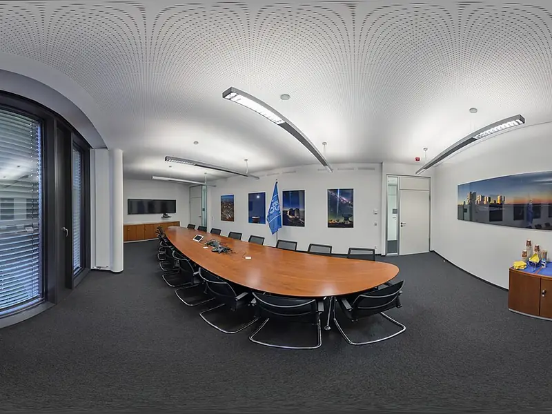 Sala de reuniões com mesa oval e telas