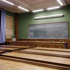 Sala de aula com carteiras de madeira e quadro-negro