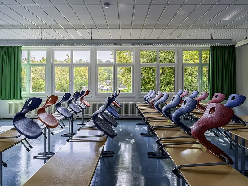 Sala de aula com mesas e cadeiras coloridas