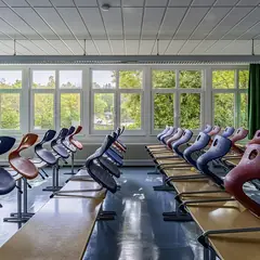 Sala de aula com mesas e cadeiras coloridas