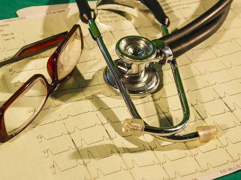 Estetoscópio e óculos sobre um eletrocardiograma