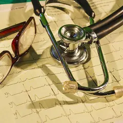 Estetoscópio e óculos sobre um eletrocardiograma