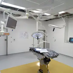Sala de cirurgia moderna e vazia, com mesa e focos de luz