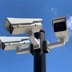 Câmeras de vigilância em um poste contra o céu azul
