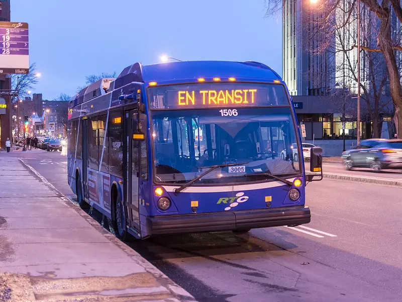 Ônibus urbano em uma rua ao entardecer