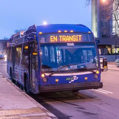 Ônibus urbano em uma rua ao entardecer